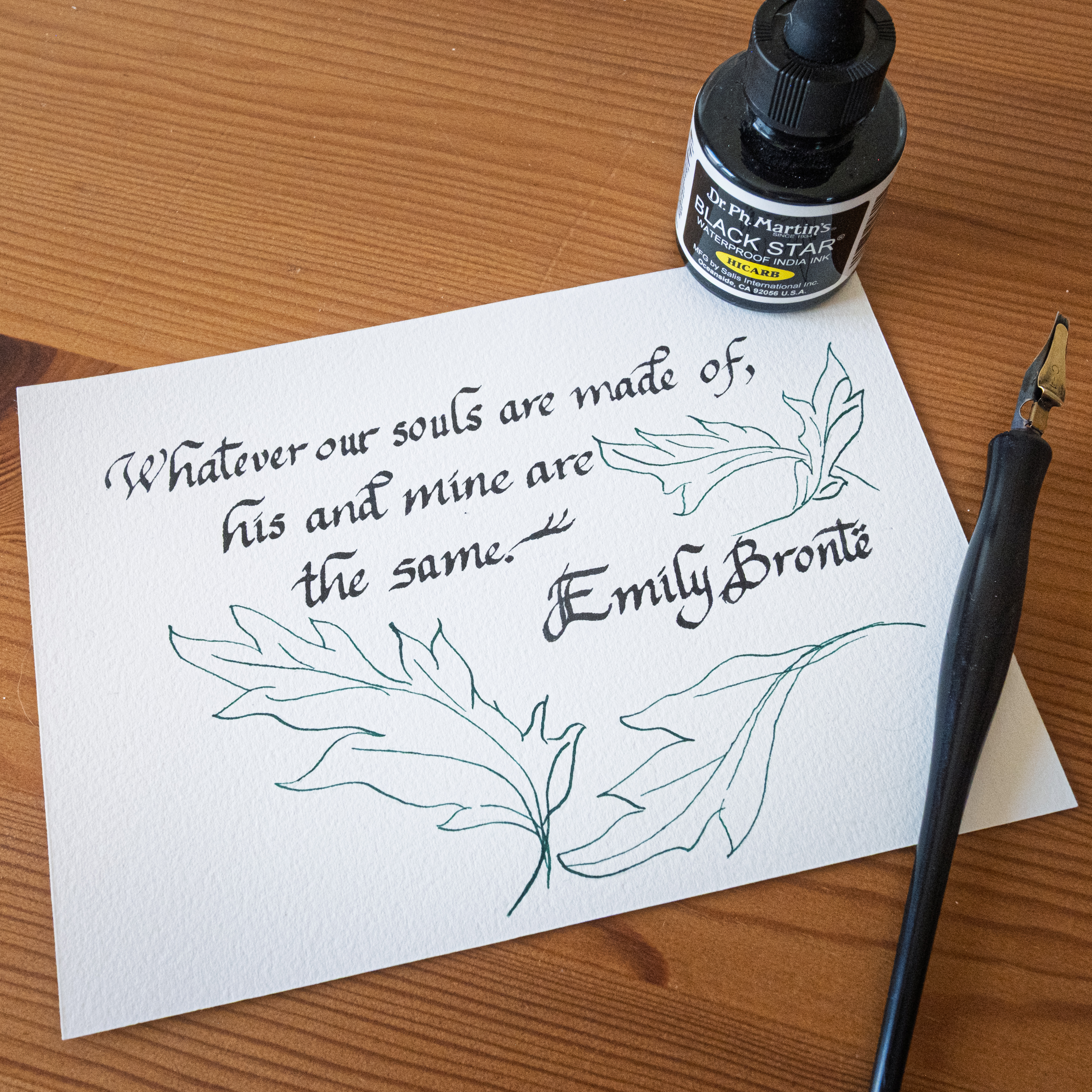 Emily Bronte quote in green calligraphy with leaf drawings on handmade paper