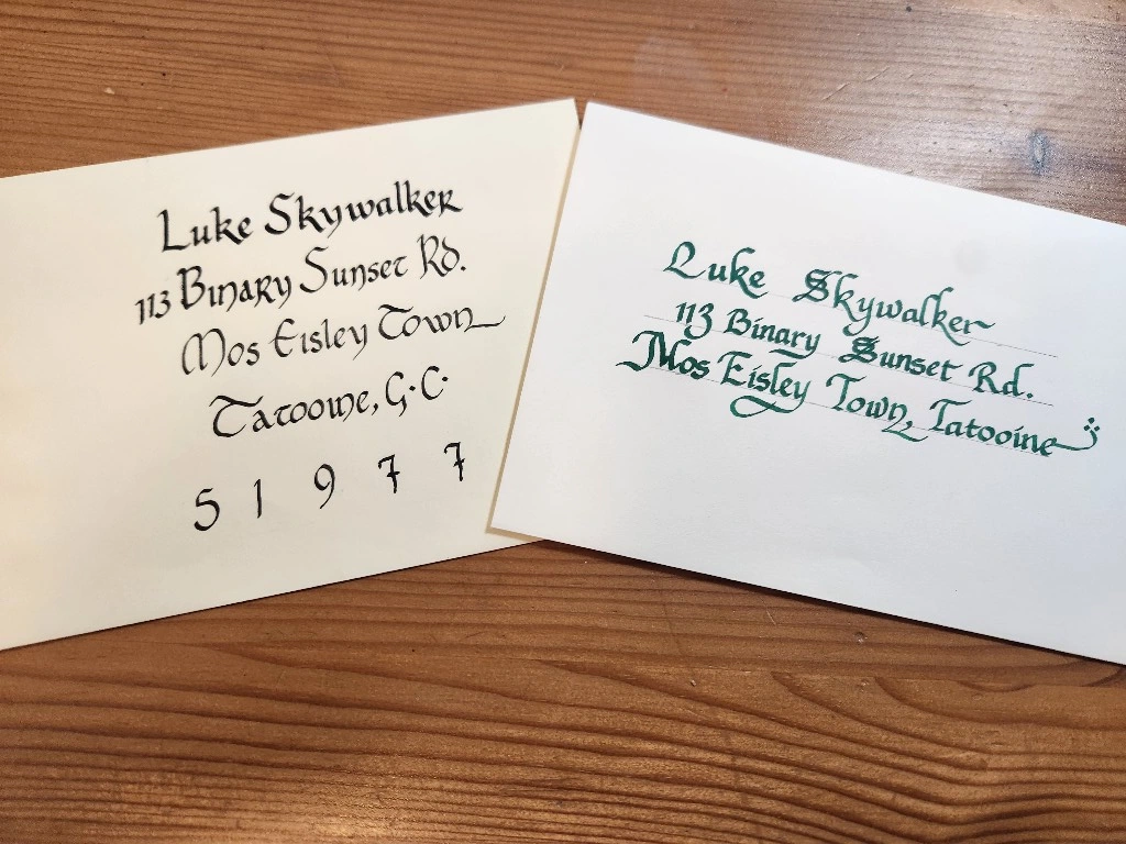 Two hand-addressed envelopes featuring black and green calligraphy