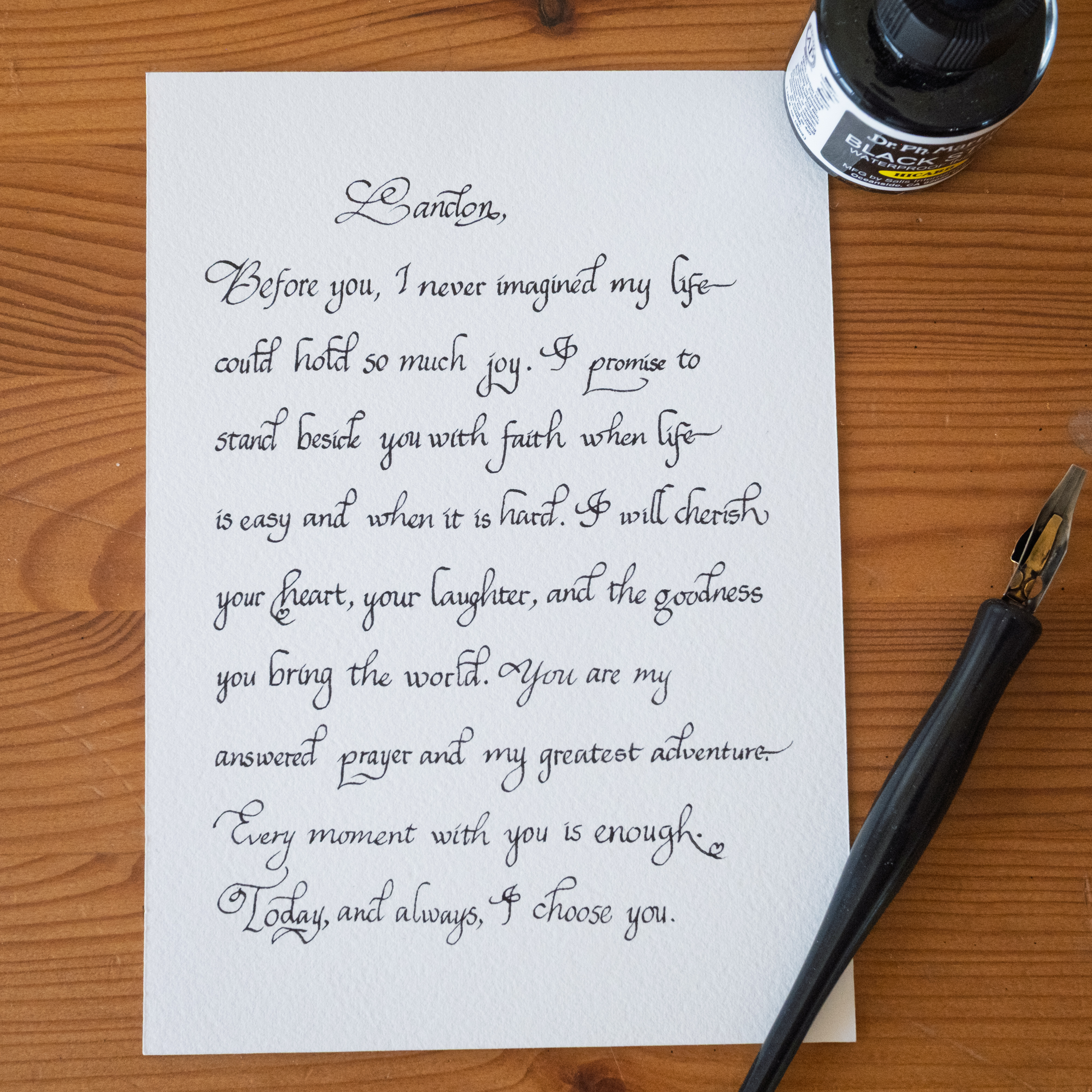 Wedding vow letter in cursive calligraphy on paper beside a candle and lavender