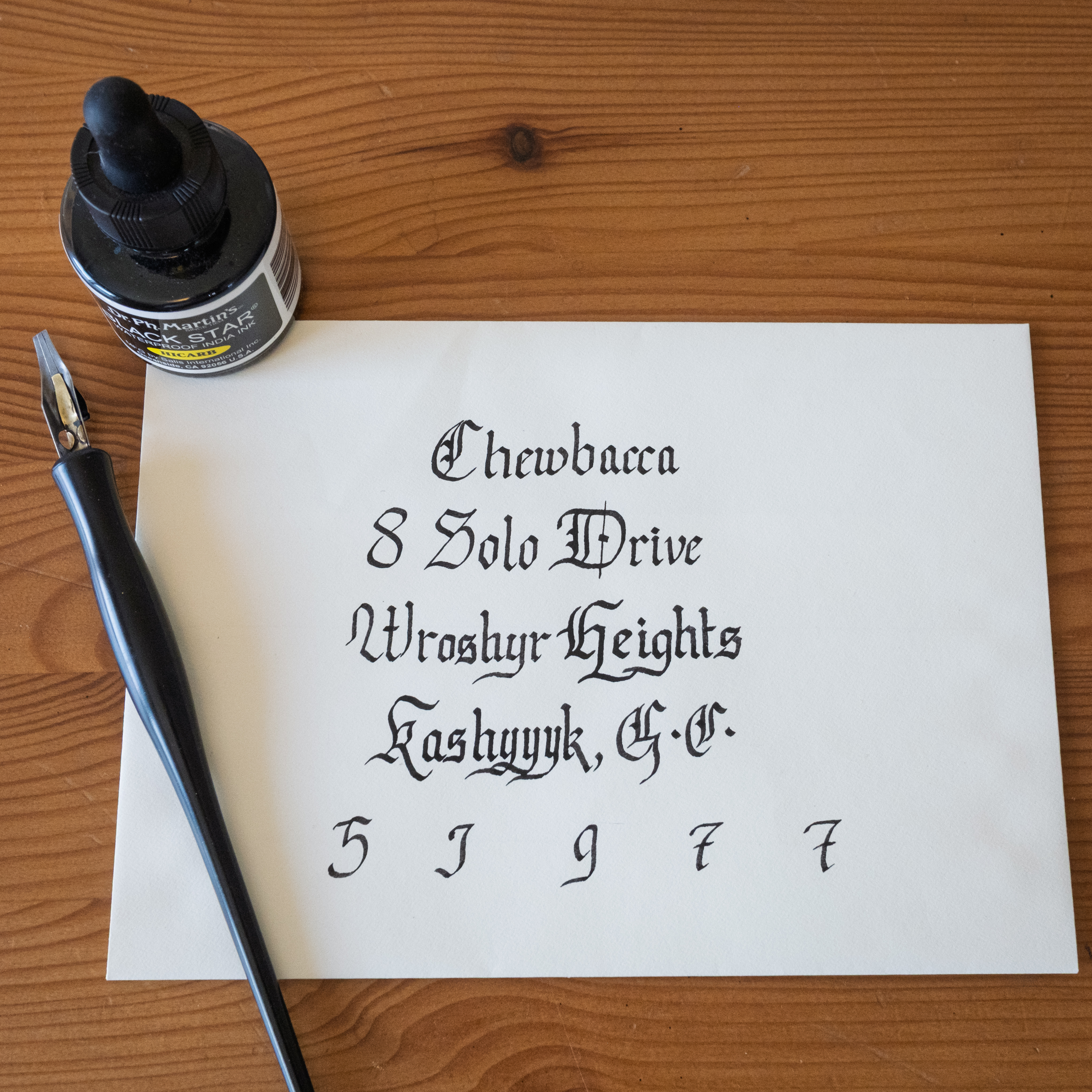 Sheet music calligraphy study on white paper beside an ink bottle and dip pen