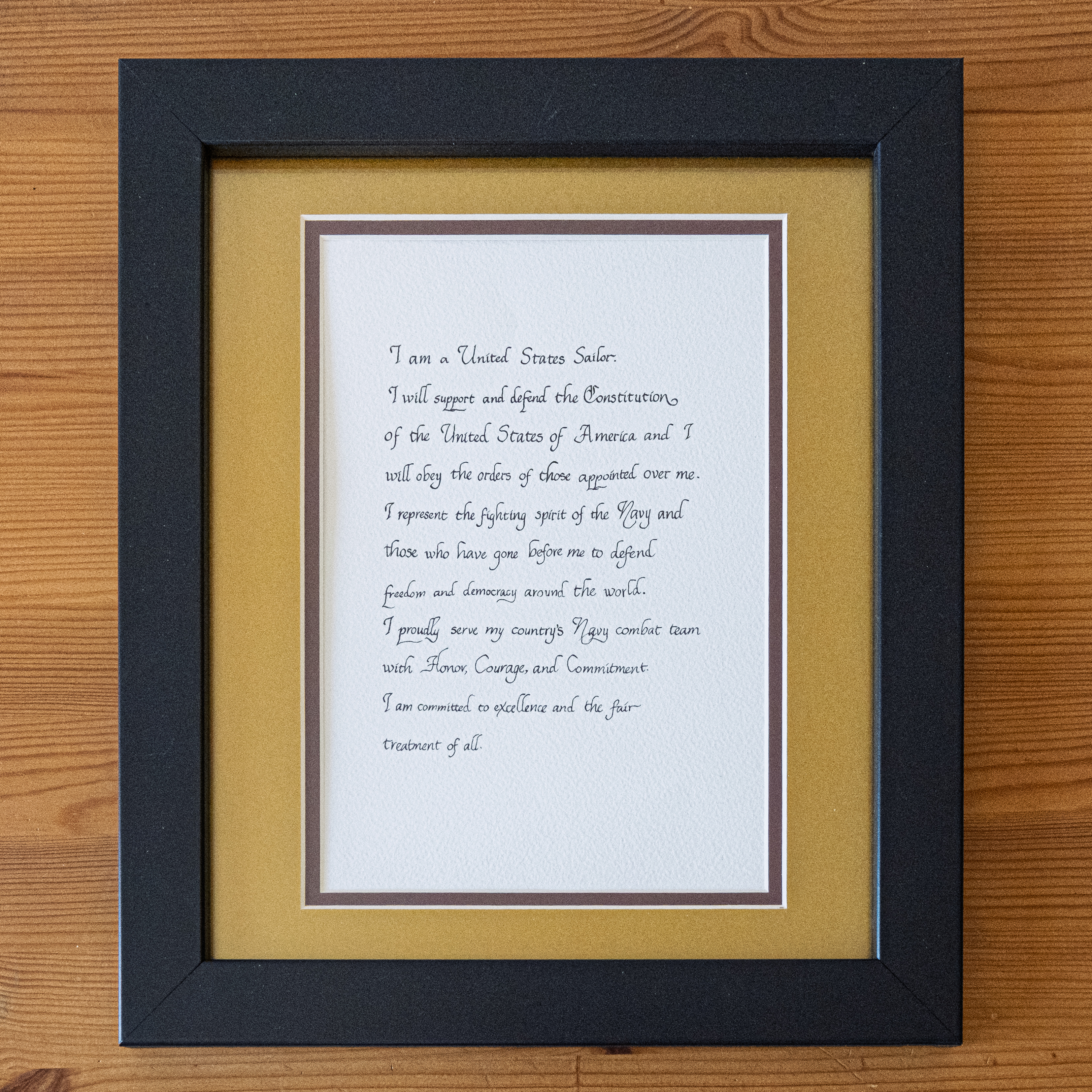 Framed cursive wedding vow calligraphy in a black and gold frame